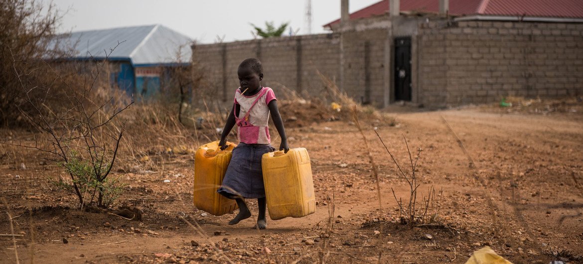 یک کودک قوطی‌های خالی جری را حمل می‌کند تا از یک شیر آب در نزدیکی آب پر کند که آب تصفیه‌نشده رودخانه نیل در جوبا، سودان جنوبی را تامین می‌کند.
